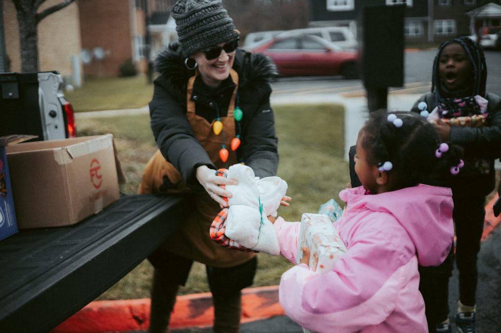 volunteer-in-a-christmas-costume-giving-a-present-to-a-little-girl-14831743 Volunteer in a Christmas Costume Giving a Present to a Little Girl